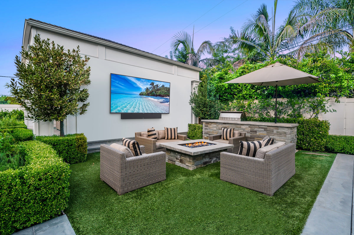 Peerless-AV ODTV5504-1500 outdoor TV installed on patio with soundbar