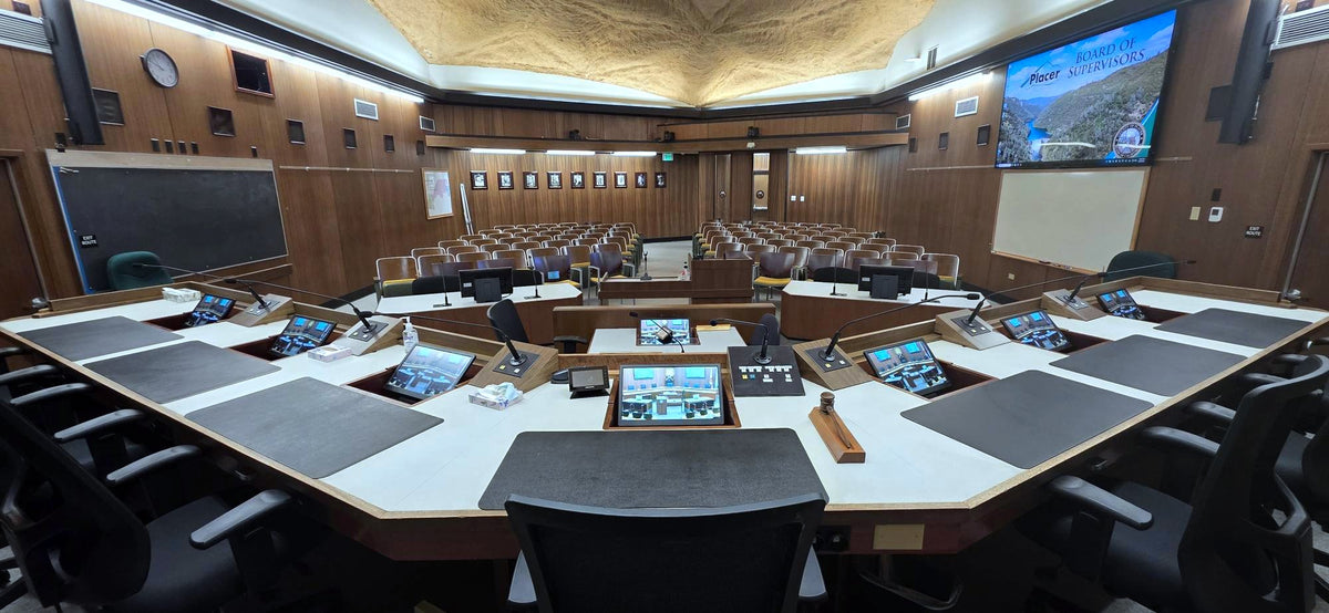 The Placer County Board of Supervisors chamber in Auburn, California, with Shure MX418S/C gooseneck microphones at the dais and a confidence monitor at each position.