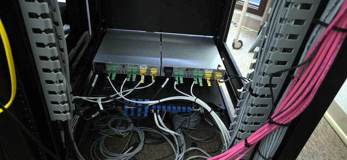 Two Biamp Tesira AMP-A460H four-channel amplifiers installed in the audio rack of the Placer County Board of Supervisors chamber in Auburn, California.