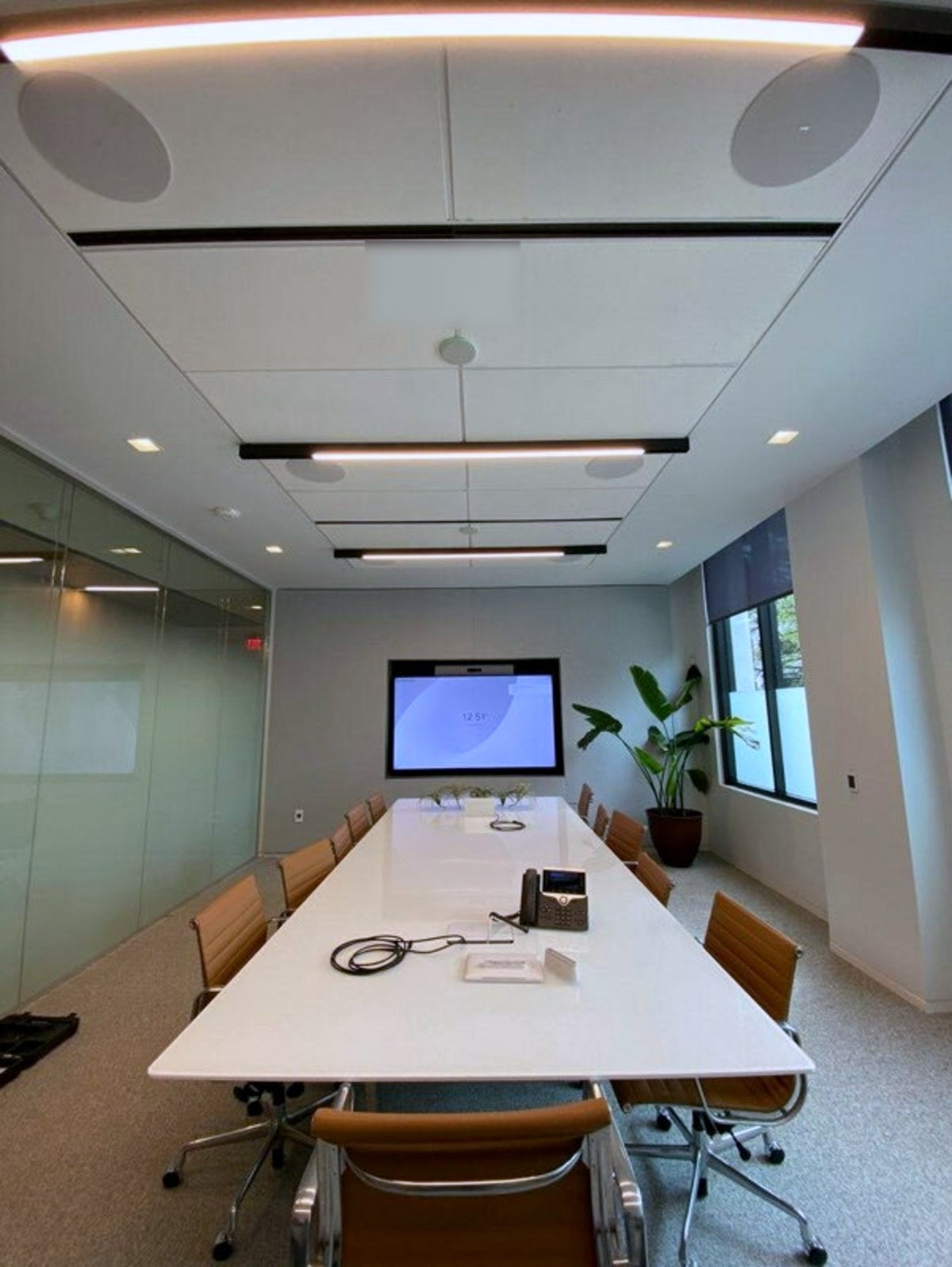Room 203 at Brevan Howard's Austin office, with a Sony BRAVIA FW-85BZ40H display at the end of the table and a Biamp Parlé TCM-X ceiling microphone between the ceiling loudspeakers.
