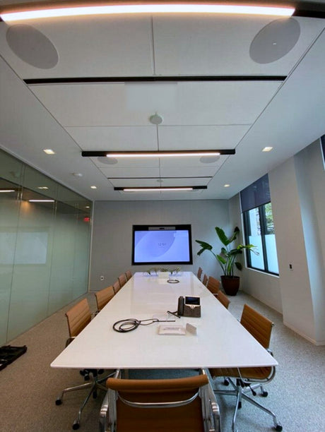 Room 203 at Brevan Howard's Austin office, with a Sony BRAVIA FW-85BZ40H display at the end of the table and a Biamp Parlé TCM-X ceiling microphone between the ceiling loudspeakers.