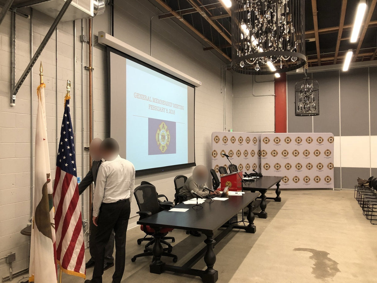 The Local 798 auditorium in San Francisco set for a general membership meeting, with the motorized projection screen, head table microphones, podium and union backdrop.