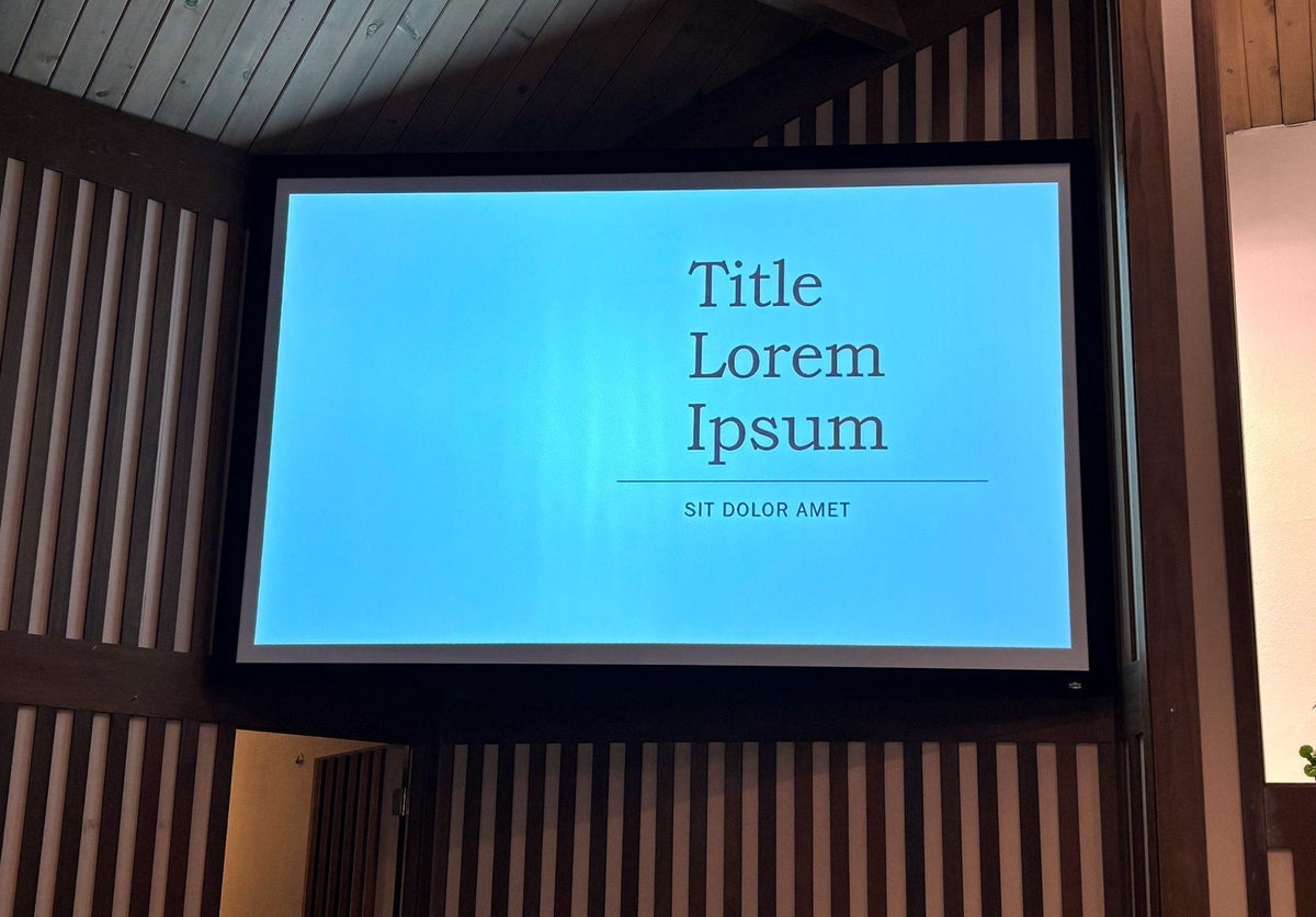 A 137 inch Da-Lite Cinema Contour fixed-frame screen mounted on the slatted side wall of the Chinese Grace Bible Church sanctuary in Sacramento, lit by an Epson EB-PU1006W laser projector.