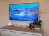 A wall-mounted display above a white credenza with a conference phone at VMG Partners' Presidio office in San Francisco, California.