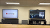 Large conference room at San Mateo County HSA with two 86-inch Avocor AVH-8620 interactive displays on AV credenzas, a camera above the right display and ceiling loudspeakers overhead