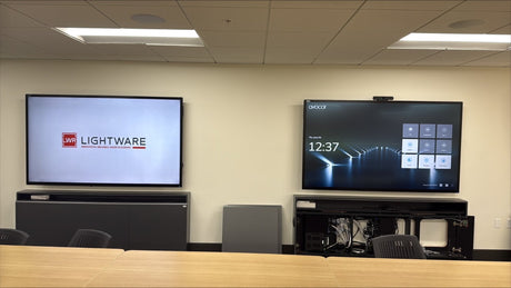 Large conference room at San Mateo County HSA with two 86-inch Avocor AVH-8620 interactive displays on AV credenzas, a camera above the right display and ceiling loudspeakers overhead