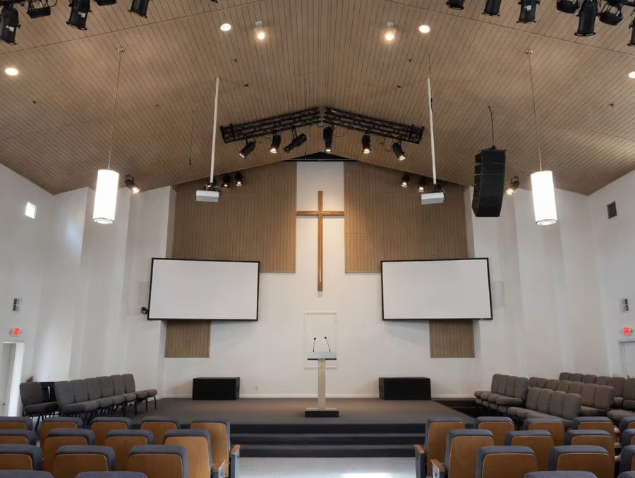 Interior of a church with a cross, pulpit, and seating.