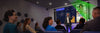 A presentation in progress with audience observing a screen.