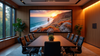 Modern conference room with large screen displaying a coastal sunset.