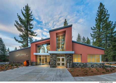 Modern building surrounded by trees under a cloudy sky.