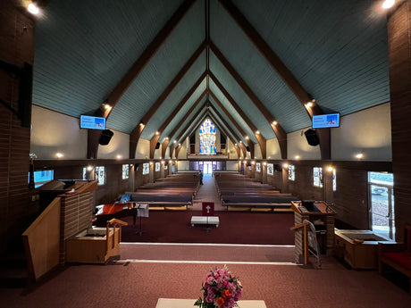 Interior view of a church with a central aisle and decorative elements.
