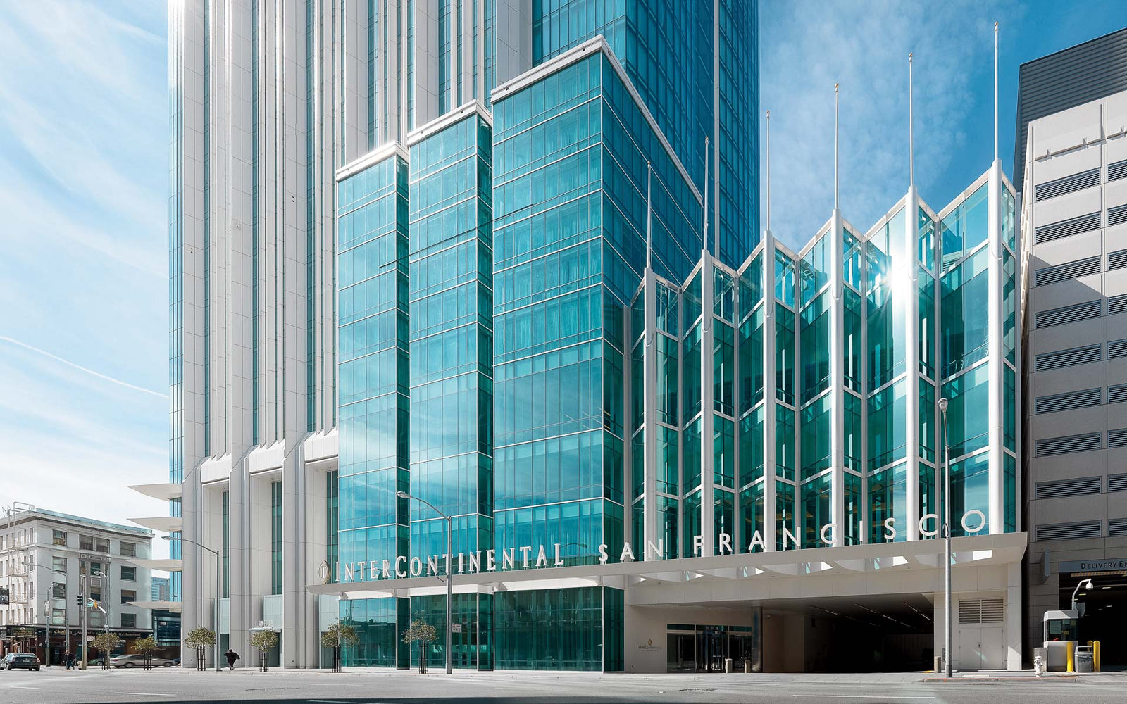 Modern glass building with unique architectural design and clear blue sky.