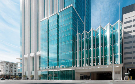 Modern glass building with unique architectural design and clear blue sky.